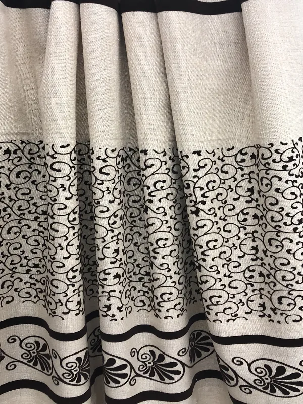 Luxurious ivory linen curtains with intricate black scrollwork patterns, softly draped to highlight elegant folds and timeless interior design.