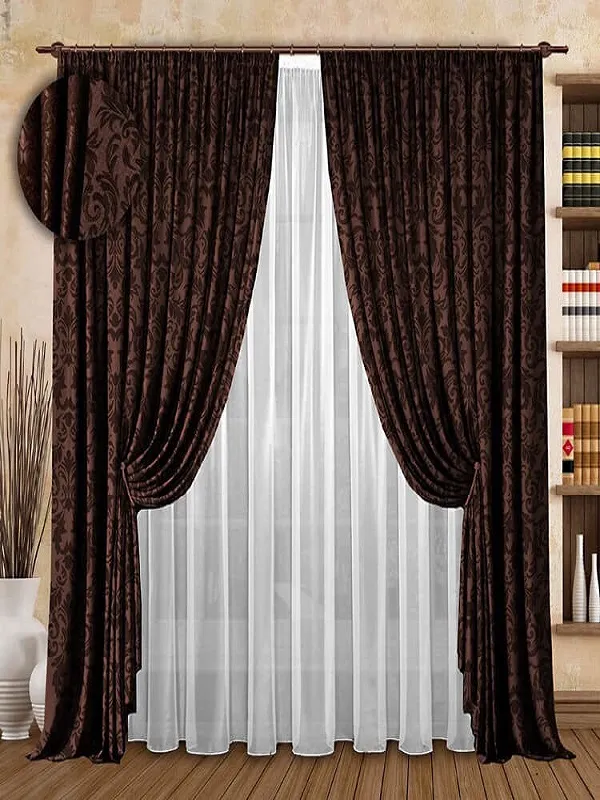 Роскошные бархатные шторы с узором висят на карнизе, за ними — прозрачный тюль. Интерьер с деревянным полом и книжными полками. Тёплый свет, уютная атмосфера.