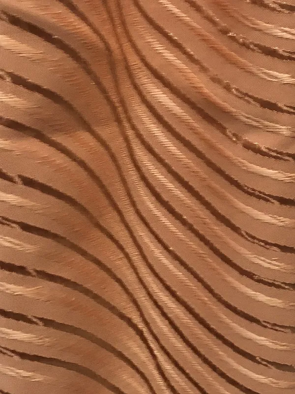 Лёгкие шторы с золотистым узором висят на окне, мягко рассеивая дневной свет. Интерьер уютный, с тёплым освещением. Ткань колышется от ветерка, создавая ощущение движения и лёгкости.