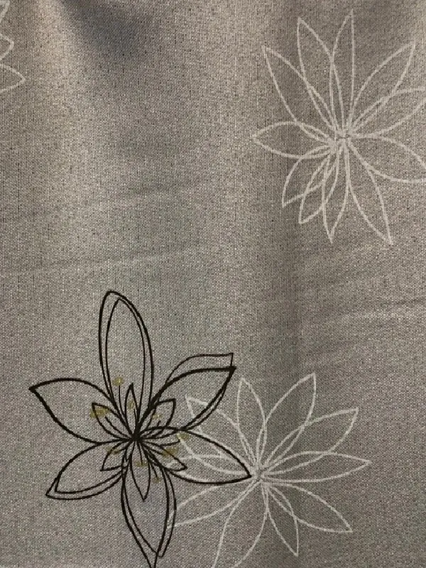 Лёгкие льняные шторы с тонкими цветочными узорами в серых тонах, мягко падают на окне, пропуская рассеянный свет, создаёт умиротворяющую атмосферу в спальне.