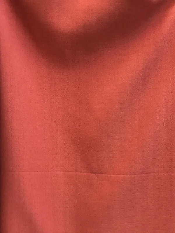 Terracotta linen drape softly draped over a window, catching golden morning light with natural folds and organic texture, evoking warmth and timeless elegance in a modern living room.