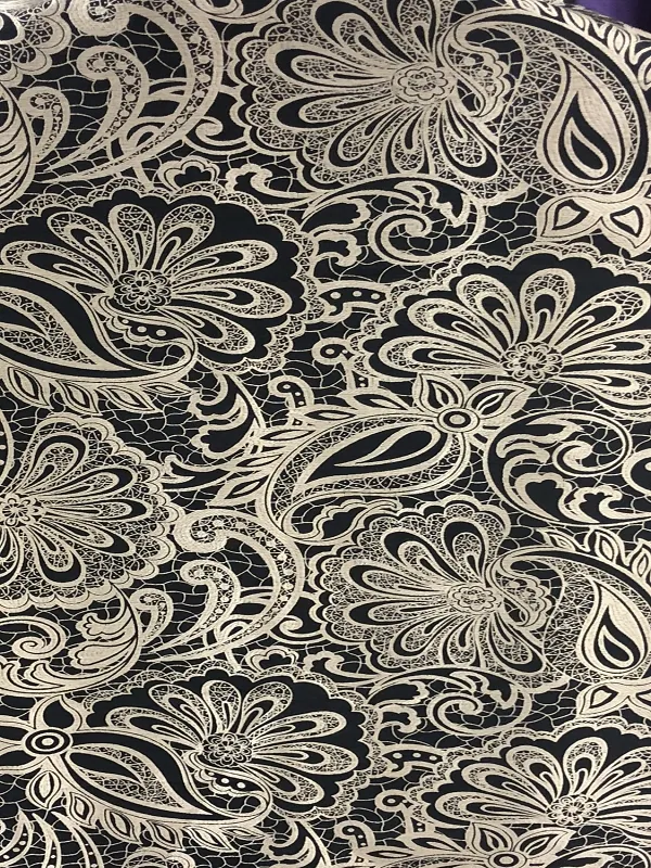 Velvet curtains with intricate gold floral lace pattern, draped elegantly over a window, casting soft shadows in a luxurious interior.