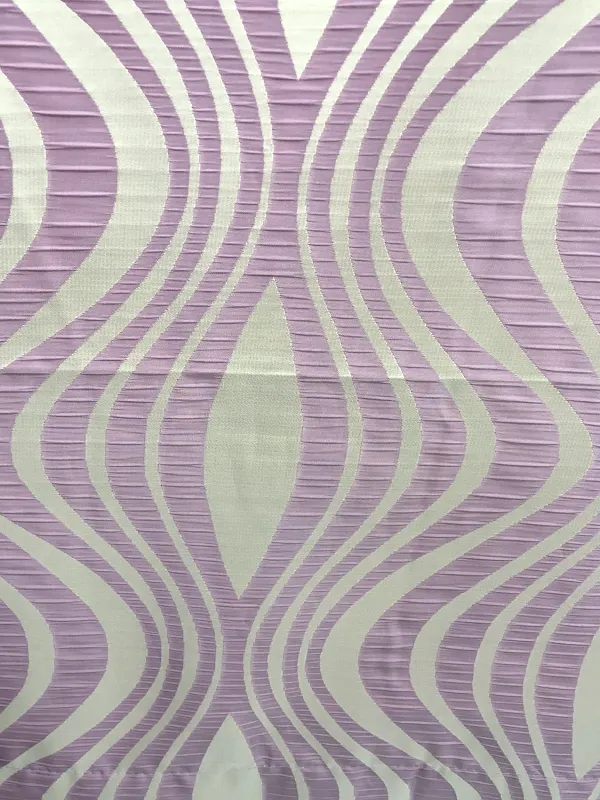 Шторы с волнообразным узором в пастельных тонах висят на окне, мягко рассеивая дневной свет. Интерьер выглядит утончённо и спокойно, как утро в саду. Ткань слегка колышется, создавая ощущение лёгкости и воздушности.