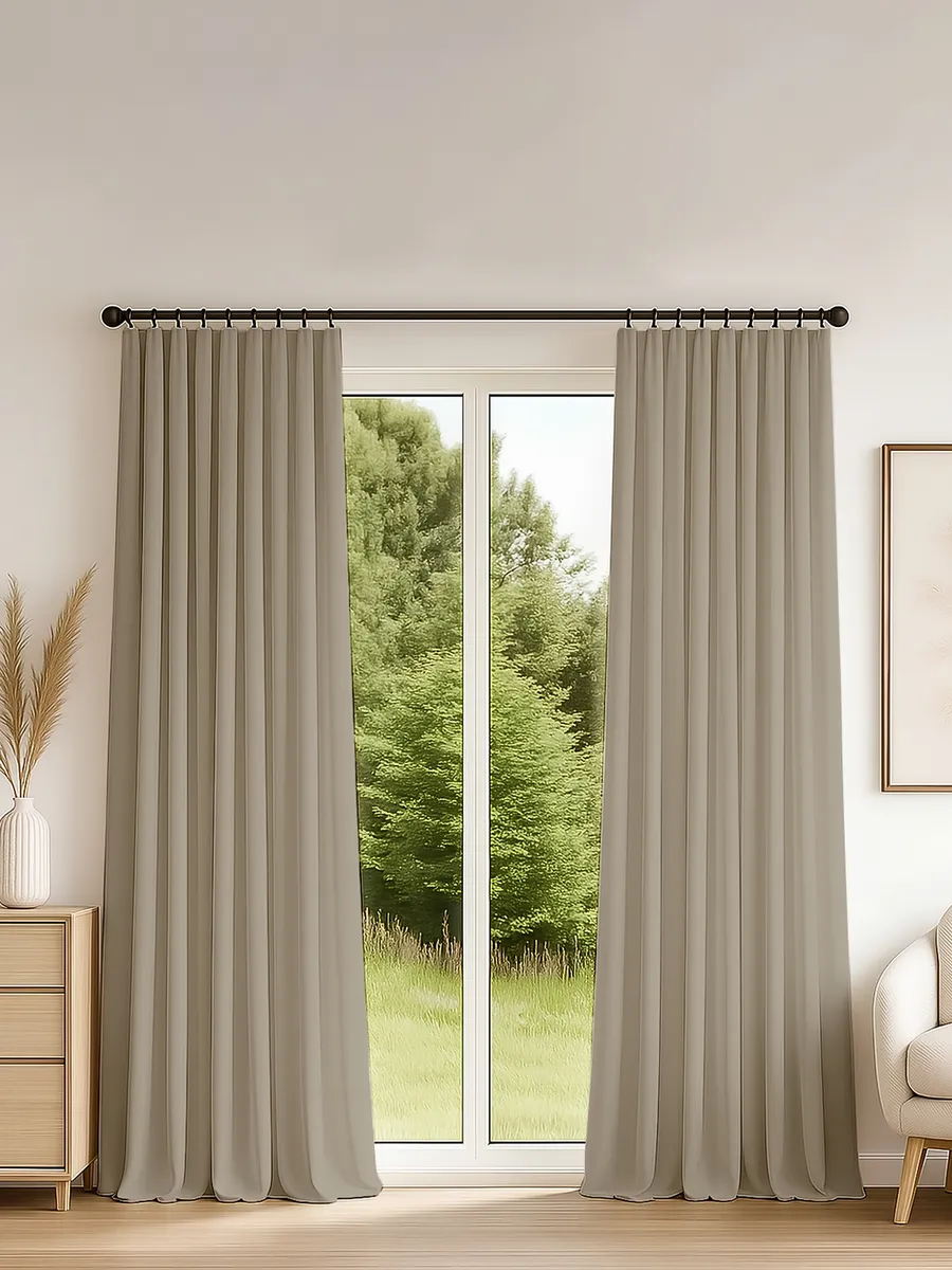Elegant tape-mounted curtains in warm oak tones frame a glass door to a lush green garden, creating a serene, modern living space with natural light and soft drape.