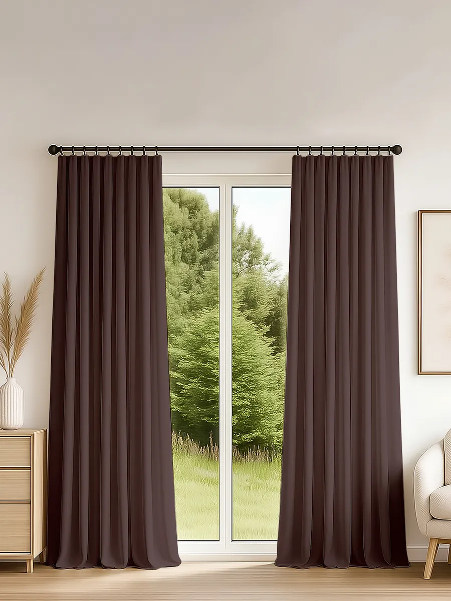 Тёмные шторы на ленте висят у большого окна, за которым виден зелёный лес. В комнате светлые стены, деревянный пол и уютная мебель. Ткань плавно струится, создавая атмосферу спокойствия и уюта.