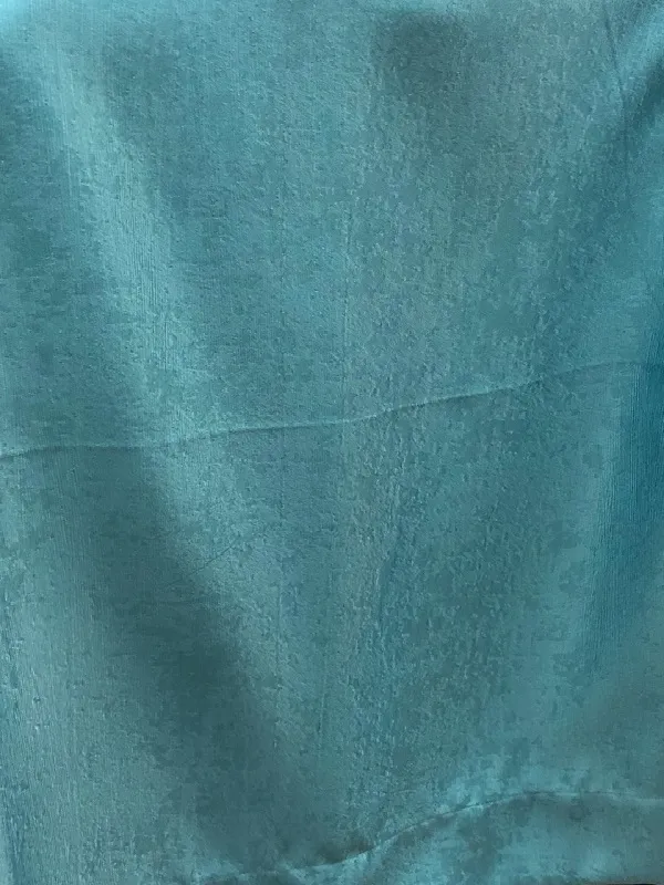 Текстиль с рельефной фактурой в синих тонах висит на окне, мягкий дневной свет проходит сквозь него, создавая уютную атмосферу в спальне.