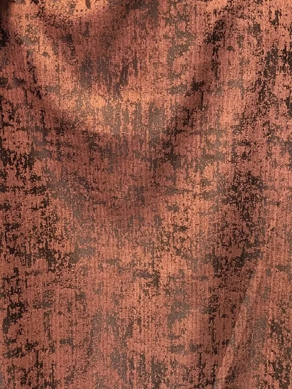 Тяжёлая ткань с рельефной поверхностью в тёплых бронзовых тонах, мягко падает на окно, отбрасывая тени на стену, создаёт уютную и арт-интенсивную атмосферу в интерьере.