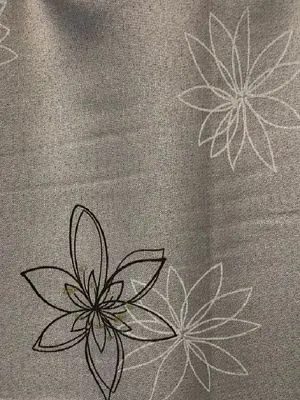 Лёгкие льняные шторы с тонкими цветочными узорами в серых тонах, мягко падают на окне, пропуская рассеянный свет, создаёт умиротворяющую атмосферу в спальне.