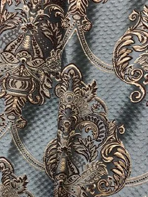 Close-up of luxurious velvet damask curtain with intricate golden embroidery, draped elegantly against a dark backdrop, showcasing opulent texture and refined detail.