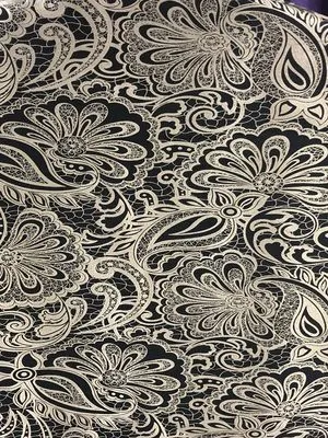 Velvet curtains with intricate gold floral lace pattern, draped elegantly over a window, casting soft shadows in a luxurious interior.