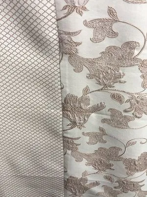 В интерьере с мягким естественным освещением, тюль с сеткой и вышитая портьера с цветочным узором создают атмосферу утончённой элегантности. Ткань лёгко колышется, пропуская рассеянный свет и подчёркивая утончённый дизайн окна.