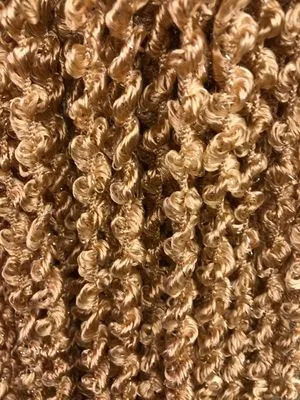 Золотистая кисея из тонких нитей висит на окне, мягко колышется от ветерка, пропуская рассеянный свет. Интерьер в тёплых тонах, уютное пространство с игрой света и тени. Декоративный элемент, создающий атмосферу мечтательности и изысканности.