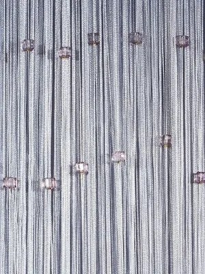 Серебристая кисея с кистями висит на окне, мягко рассеивая свет и создавая атмосферу волшебства. Тонкие нити колышутся от ветерка, отражая солнечные лучи. Интерьер выглядит утончённо и романтично, как в сказке.