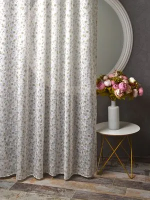 Лёгкий тюль с золотистым цветочным узором висит в мягком свете, рядом — круглое зеркало и ваза с розовыми розами на золотом столике, создаёт уютную и элегантную атмосферу.